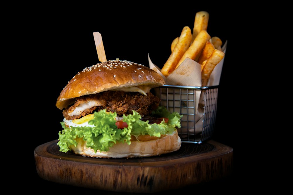 Burger ayam goreng renyah dengan selada, disajikan bersama kentang goreng