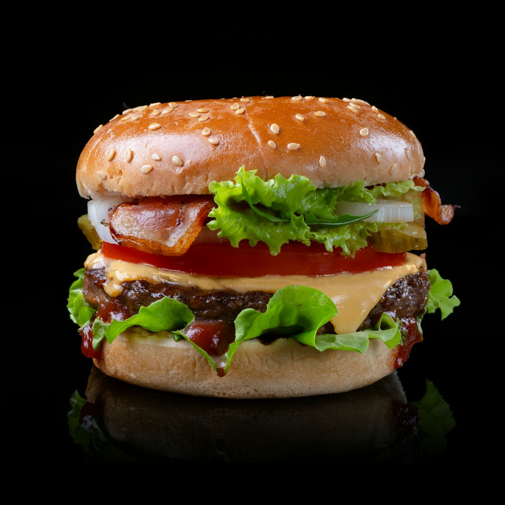Burger dengan patty daging, keju, tomat, bawang, dan selada
